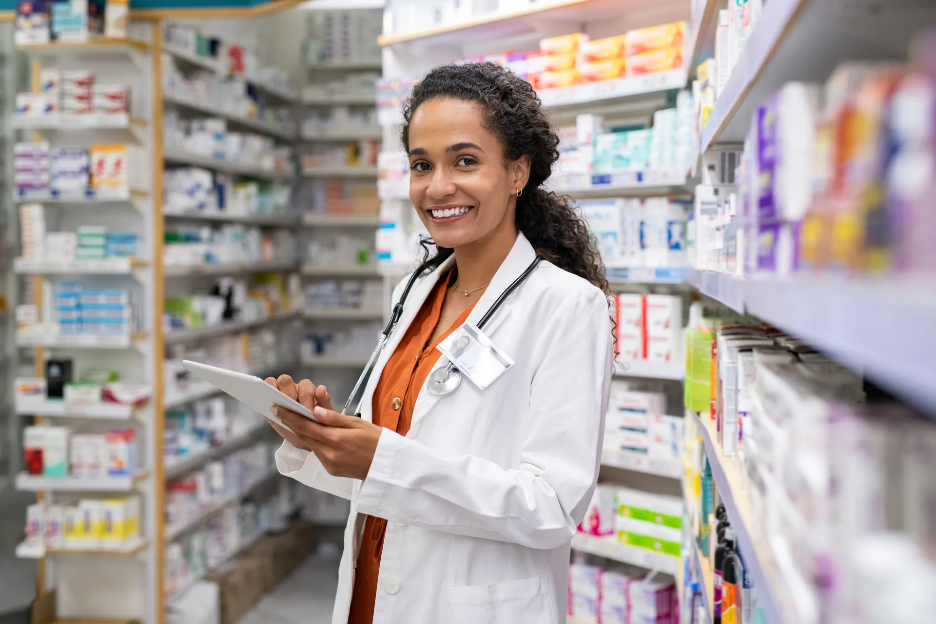 Pharmacist with tablet in pharmacy
